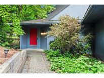 Charming home featuring a vibrant red front door, complemented by stone walkway and landscaped surroundings at 3863 Dundee Ne Dr, Roswell, GA 30075