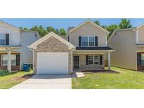 Charming two-story home featuring a brick and vinyl exterior, attached garage, and well-maintained front lawn at 5280 Tussahaw Xing, Mcdonough, GA 30252