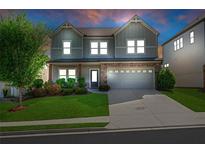 Charming two-story home features a stone accent garage and manicured front lawn at 5751 Green Arbor Way, Sugar Hill, GA 30518