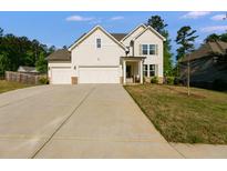 Charming two-story home with a three-car garage and a well-manicured front lawn at 174 Riverwood Dr, Dallas, GA 30157