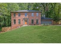 Brick home with a beautiful lawn, a two-car garage and an elegant front entryway at 1430 Dallas Circle Sw, Marietta, GA 30064