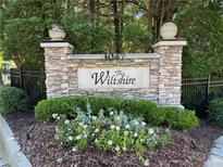 Stone community sign for The Wiltshire with manicured landscaping at 3047 Lenox Ne Rd # 2105, Atlanta, GA 30324
