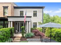 Charming home featuring a manicured front yard, covered porch with columns and an American flag at 727 Hammond Dr, Woodstock, GA 30188