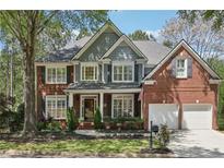 Charming two-story brick home with a well-manicured lawn, professional landscaping, and attached two car garage at 8640 Amsbury Way, Cumming, GA 30041