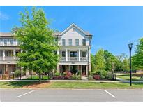 Charming townhome featuring a two-story facade with a covered porch and beautifully landscaped front yard at 130 Inwood Walk, Woodstock, GA 30188