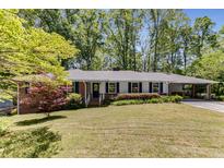 Charming single-story home with brick accents, covered parking, and mature trees at 2357 Burnt Creek Rd, Decatur, GA 30033