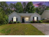 Charming one-story home boasts a well-maintained lawn and colorful flowering bushes at 25 Bridlewood Ct, Stockbridge, GA 30281