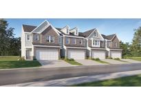 New townhome construction showcasing brick and siding facade with two-car garage and professionally landscaped front yard at 2815 Habibi Ct, Buford, GA 30519