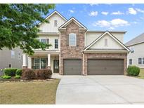 Beautiful two-story home featuring stone accents, a two-car garage, and a well-manicured lawn at 5760 Palmtree Pass, Cumming, GA 30040