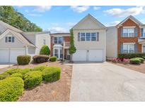 Charming two-story townhome with a manicured front yard and an attached two-car garage at 1703 Bentridge Nw Dr, Kennesaw, GA 30144