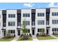 Modern townhome exterior showcasing white brick, black accents, large windows, and professional landscaping at 435 Mezzo Ln # 86, Alpharetta, GA 30009