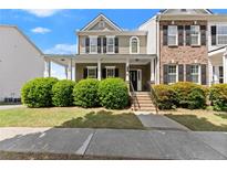 Charming two-story home featuring a welcoming front porch and lush green landscaping at 1237 Park Pass Way, Suwanee, GA 30024