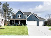 Beautiful two-story home featuring a dark blue exterior with a well-manicured lawn and two-car garage at 3548 Cedarvale Ct, Powder Springs, GA 30127