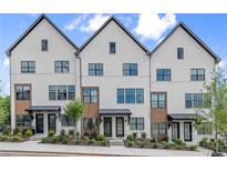 Charming townhome exterior boasts brick facade, black trim, and manicured landscaping at 656 Soul Aly # 101, Alpharetta, GA 30009