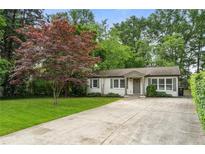 Charming single-story home with a well-manicured lawn and a concrete driveway at 2171 Plantation Ln, Chamblee, GA 30341