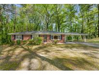 Charming single-story brick home with a spacious carport and mature trees at 618 Buchanan Hwy, Dallas, GA 30157