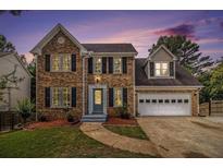 Charming two-story brick home boasts a manicured lawn, attached two car garage, and inviting curb appeal at 651 Deer Oaks Dr, Lawrenceville, GA 30044