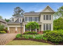 Charming two-story home with a well-manicured lawn, mature trees, and a brick driveway at 201 Hunley Ct, Alpharetta, GA 30005