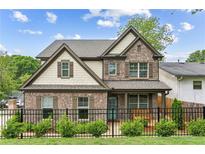 Charming two-story home with brick facade, manicured lawn, and black iron fence at 461 Silver St, Buford, GA 30518