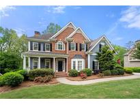 Charming two-story home with a brick and siding exterior, complemented by a well-manicured lawn and mature trees at 4877 Registry Nw Ln, Kennesaw, GA 30152
