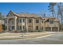 Stunning two-story brick home with stone accents, attached garage, manicured lawn, and beautiful architectural details at 2015 Shaudi Ln, Atlanta, GA 30345