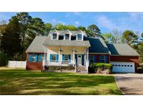 Charming two-story home with a welcoming front porch, vibrant blue shutters, and well-manicured lawn at 2949 Lake Spivey Pkwy, Jonesboro, GA 30236