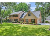 Charming brick home featuring a well-manicured lawn and mature trees, offering a serene and inviting curb appeal at 3635 Norwich Dr, Tucker, GA 30084