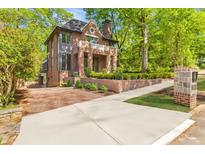 Charming brick home featuring a brick driveway, manicured landscaping, and a welcoming front entrance at 1026 Reeder Cir, Atlanta, GA 30306