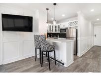 Modern kitchen featuring stainless steel appliances, white cabinetry, and breakfast bar with unique zebra-print bar stools at 215 Piedmont Ne Ave # 2210, Atlanta, GA 30308