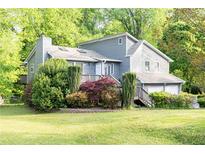 Charming gray home with lush landscaping and a welcoming front porch surrounded by mature trees at 4065 Maxanne Nw Dr, Kennesaw, GA 30144