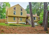 Charming two-story home with yellow siding, stone accents, and a well-maintained front yard at 5105 Davidson Ne Rd, Marietta, GA 30068