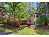 Charming two-story home featuring a well-manicured lawn with mature trees and beautiful, colorful landscaping at 1824 Mallard Lake Dr, Marietta, GA 30068