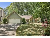 Charming single Gathering home featuring stone and siding details, lush landscaping, and an attached two-car garage at 1390 Barclay Dr, Lawrenceville, GA 30043