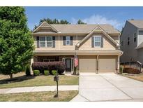 Charming two-story home with a manicured front lawn, a two-car garage, and a welcoming entrance at 120 Park Village Dr, Canton, GA 30114