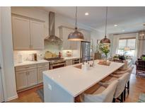 Bright kitchen with stainless steel appliances, large island with seating, and pendant lighting at 14 Lochurst Ln # 153, Roswell, GA 30076
