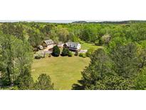 Expansive estate featuring a brick home, guest house, and ample green space surrounded by lush trees at 190 Ward Rd, Ellenwood, GA 30294