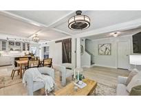 Inviting living room with a dining area, barn door, modern light fixtures and light hardwood floors at 285 Lakemoore Ne Dr # A, Atlanta, GA 30342