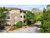 Exterior view of a brick apartment building with well-maintained landscaping and a paved parking area in front at 2700 Pine Tree Ne Rd # 1214, Atlanta, GA 30324