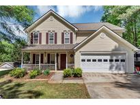 Charming two-story home with a welcoming front porch and manicured lawn at 745 Beaver Pond Trl, Fairburn, GA 30213