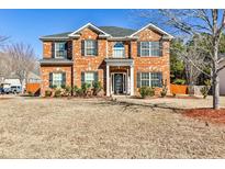 Beautiful two-story brick home with manicured lawn and black shutters on a sunny day at 5447 Stirrup Way, Powder Springs, GA 30127