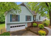 Charming two-story home with light blue siding, blue shutters, and an attached garage at 865 Turner Dr, Lawrenceville, GA 30046