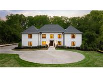 Elegant two-story home featuring a circular driveway, manicured lawn, and classic architectural details at 5260 Long Island Nw Dr, Atlanta, GA 30327