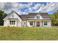 Charming two-story farmhouse featuring white siding, a cozy porch swing, and a well-manicured front lawn at 613 Nebo Rd, Dallas, GA 30157