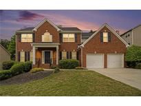 Charming brick home with a manicured lawn and two car garage at 5870 Buckner Creek Dr, Mableton, GA 30126