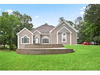 Charming single-story home with a manicured lawn and a terraced retaining wall at 2507 Fairweather Se Ct, Conyers, GA 30013