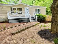 Charming home featuring a welcoming porch, neutral siding, and well-maintained front yard at 8 Dixie Dr, Stockbridge, GA 30281