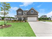 Charming two-story home with a well-manicured lawn, inviting front porch, and attached two-car garage at 837 Porches Way, Dacula, GA 30019