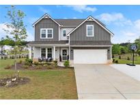 Charming two-story home featuring a well-manicured lawn, two-car garage, and inviting front porch area at 837 Porches Way, Dacula, GA 30019