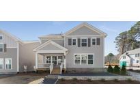 Charming two-story home with gray siding, a covered front porch, and manicured landscaping at 919 East Green Ln, Clarkston, GA 30021