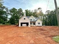 A new two-story home featuring a brick facade, attached garage, and situated on a large lot with some tree coverage in the background at 151 Tipton Ln, Acworth, GA 30102